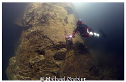 A side-mount diver descends along one of the supporting r... by Michael Grebler 